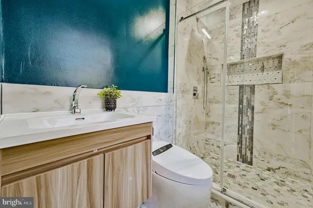 a bathroom with a sink a toilet and shower