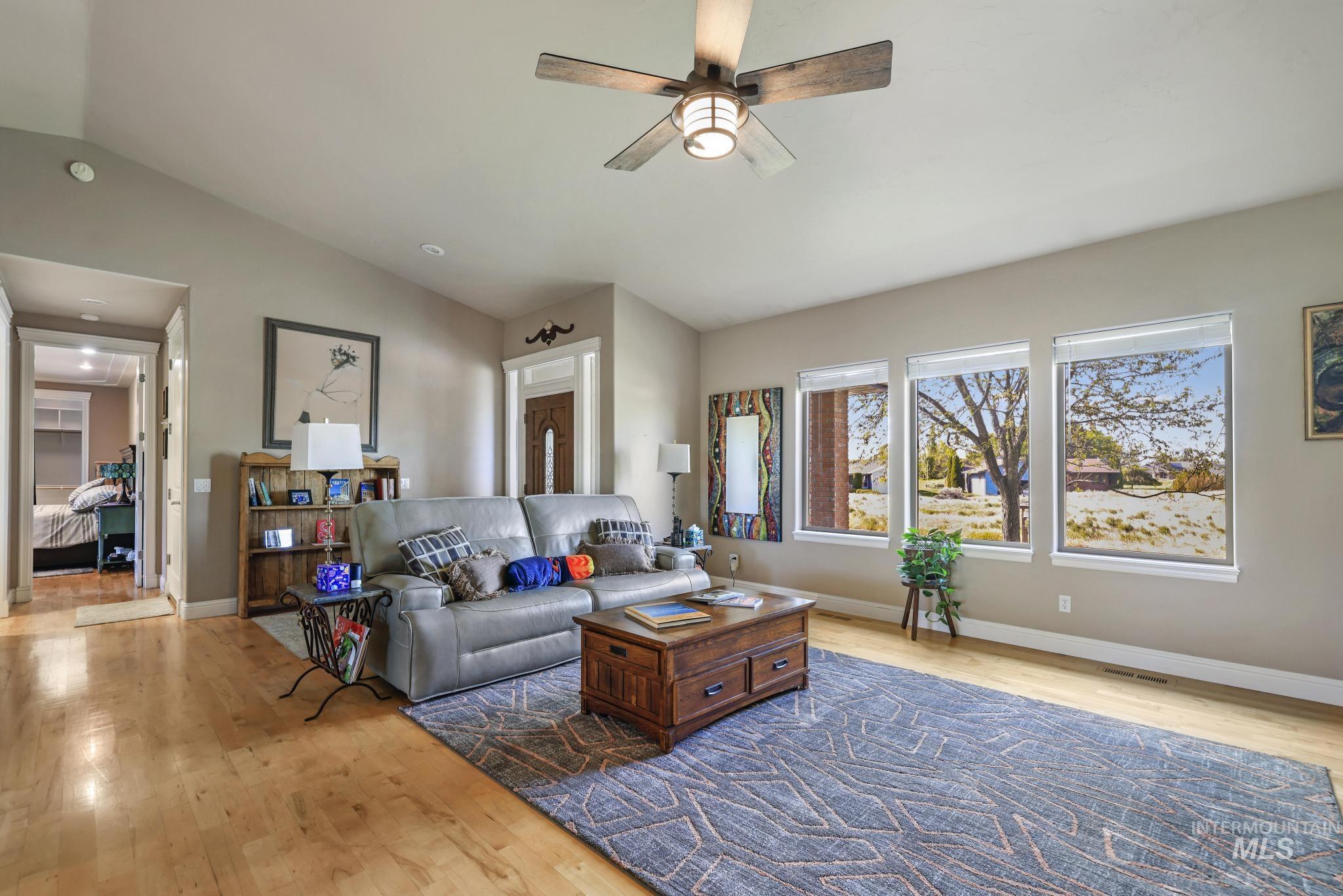 100 Olympic Road Jerome, ID 83338 - Photo 10 of 50 Spacious living area featuring light wood-finish flooring, vaulted ceilings, and a ceiling fan with integrated lighting