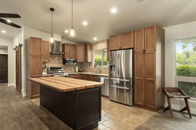 a kitchen with kitchen island a counter top space stainless steel appliances and cabinets