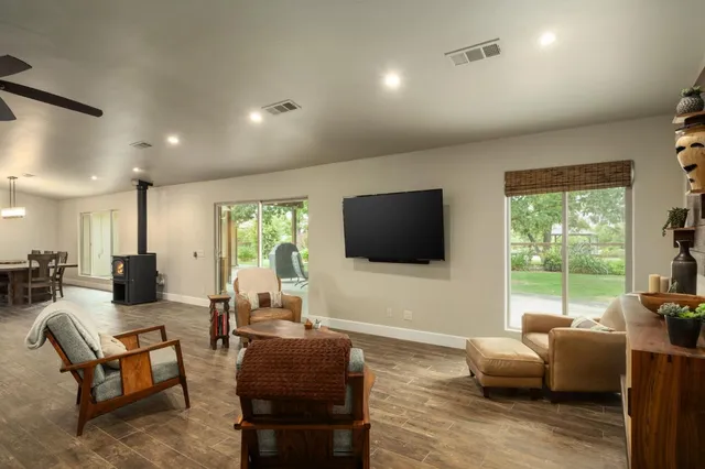a living room with furniture a flat screen tv and a large window