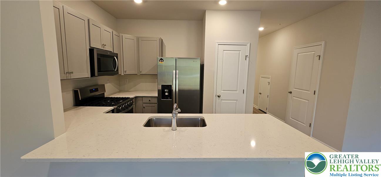 1151 Martin Road Breinigsville, PA 18031 - Photo 6 of 15 a kitchen with a refrigerator a stove top oven a sink and cabinets