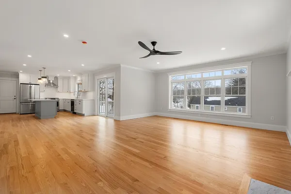 a view of empty room with wooden floor and windows