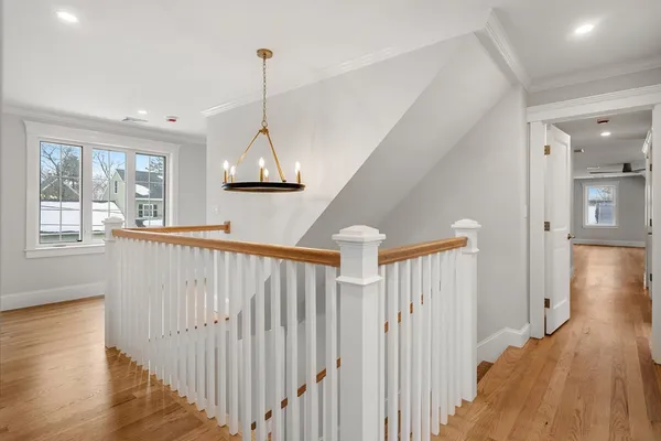 a view of a hallway with wooden floor and windows