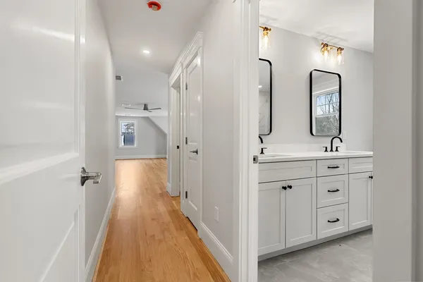 a spacious bathroom with a double vanity sink double mirror and bathtub