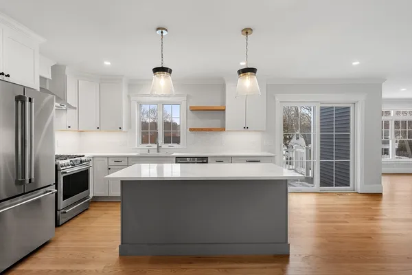 a kitchen with stainless steel appliances granite countertop a sink stove and refrigerator