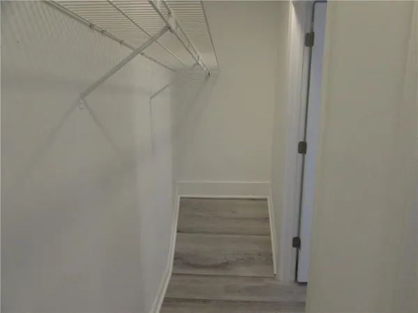 a view of walk in closet with empty racks