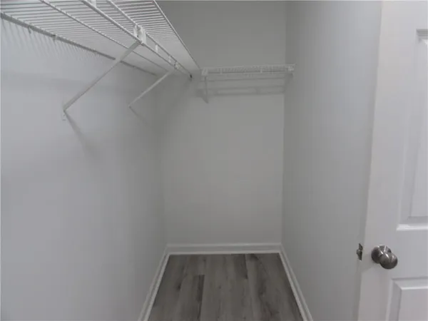 a view of walk in closet with empty racks