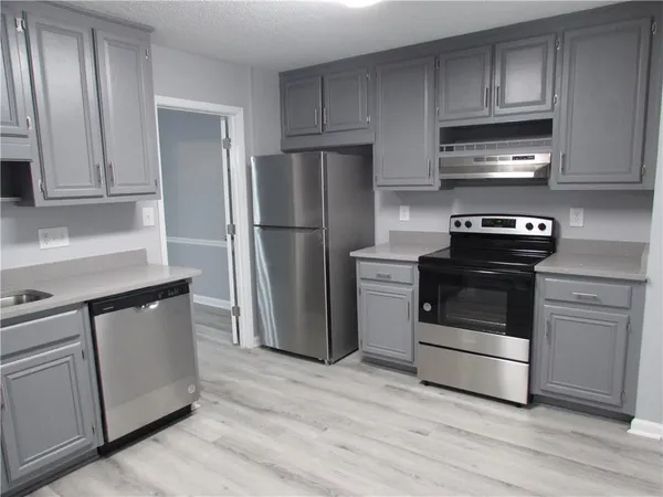 a view of a kitchen with refrigerator and window