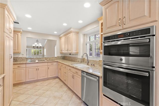 a kitchen with granite countertop a stove microwave and sink