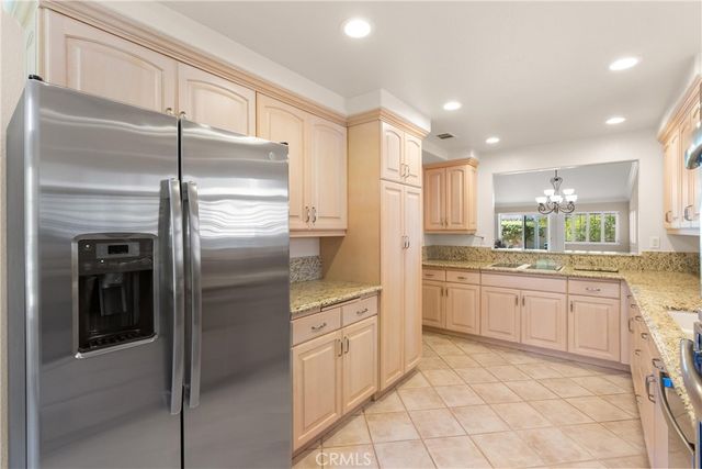 a kitchen with stainless steel appliances granite countertop a refrigerator and a sink