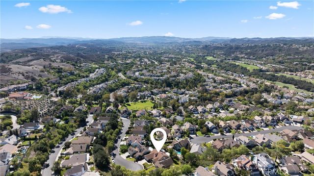 an aerial view of residential houses with outdoor space and trees