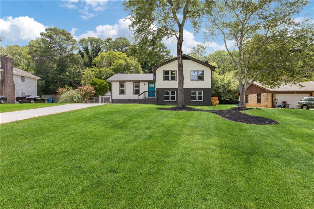 a front view of a house with a yard and trees