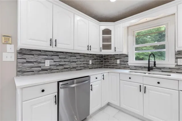 a kitchen with a sink appliances and cabinets