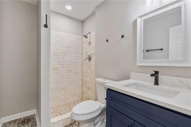 an empty room with windows a fireplace and wooden floor