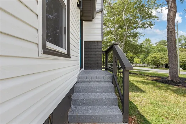 an empty room with wooden floor and kitchen view