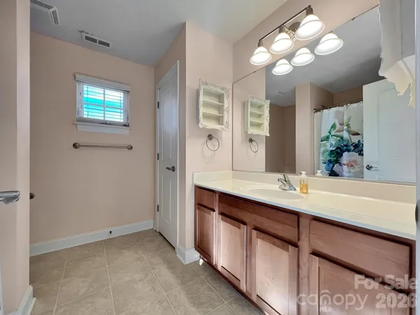 a bathroom with a sink a large mirror and a light fixture