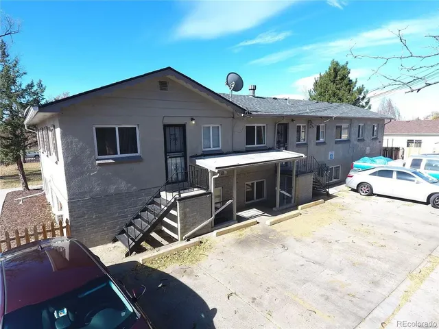 a view of a house with chairs and wooden fence