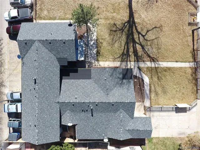 an aerial view of a house with a yard and large tree