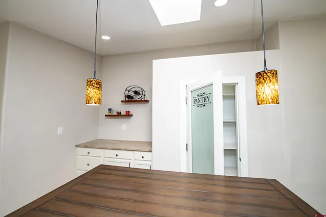 a kitchen with wooden floor and stainless steel appliances