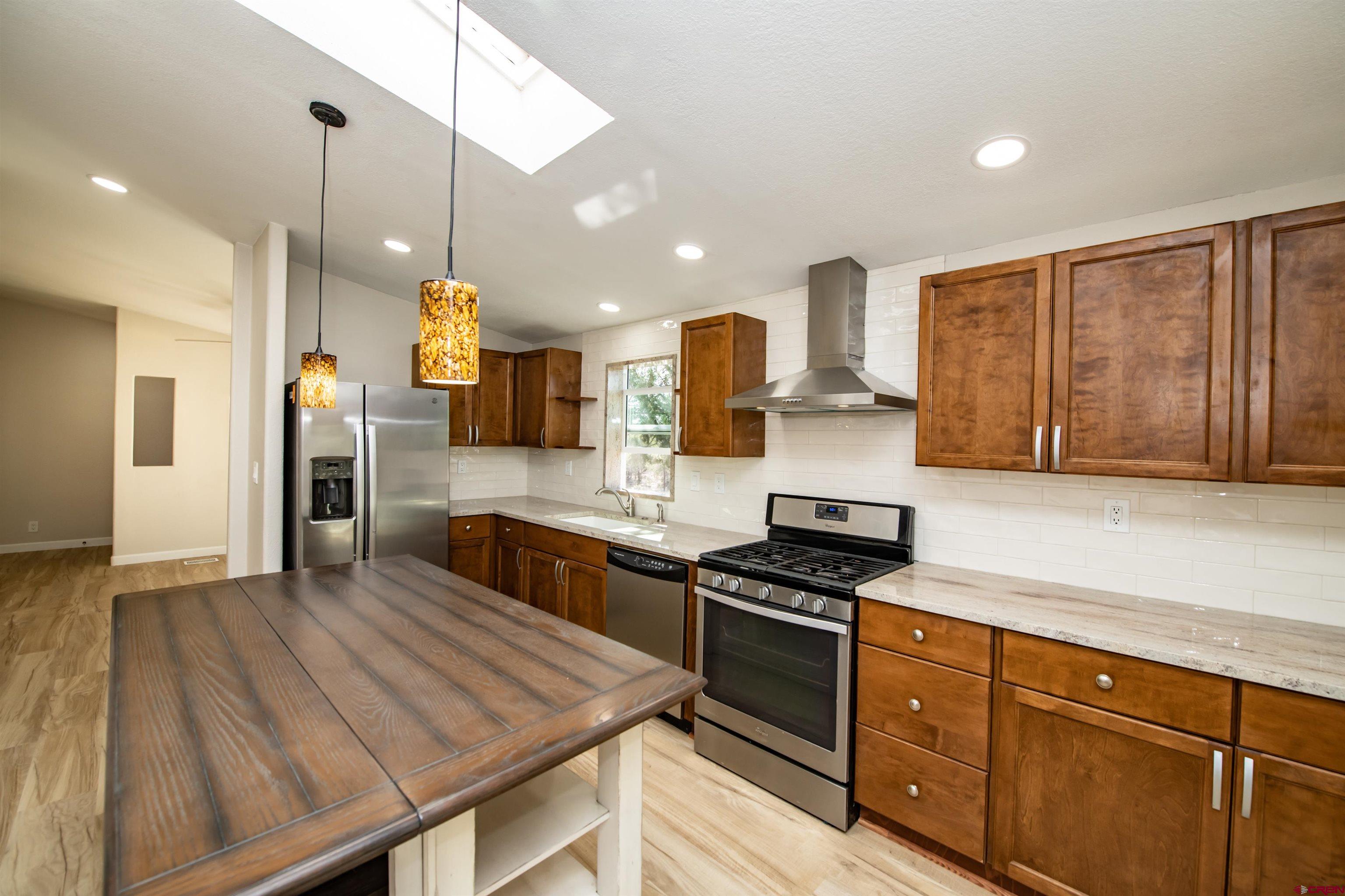 475 Run Around Road Arboles, CO 81121 - Photo 14 of 40 a kitchen with wooden floor and stainless steel appliances