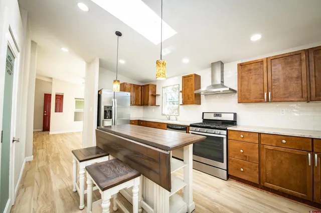 a kitchen with kitchen island granite countertop a sink cabinets and wooden floor