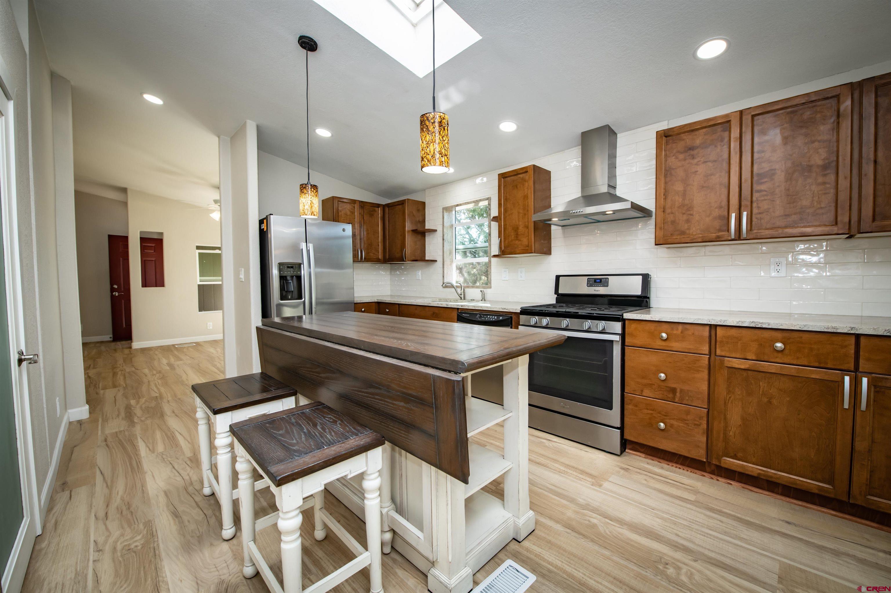 475 Run Around Road Arboles, CO 81121 - Photo 16 of 40 a kitchen with kitchen island granite countertop a sink cabinets and wooden floor