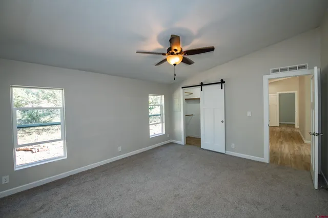a view of a livingroom with a window and a ceiling fan