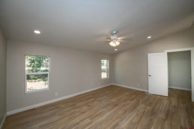 an empty room with a window and a fan