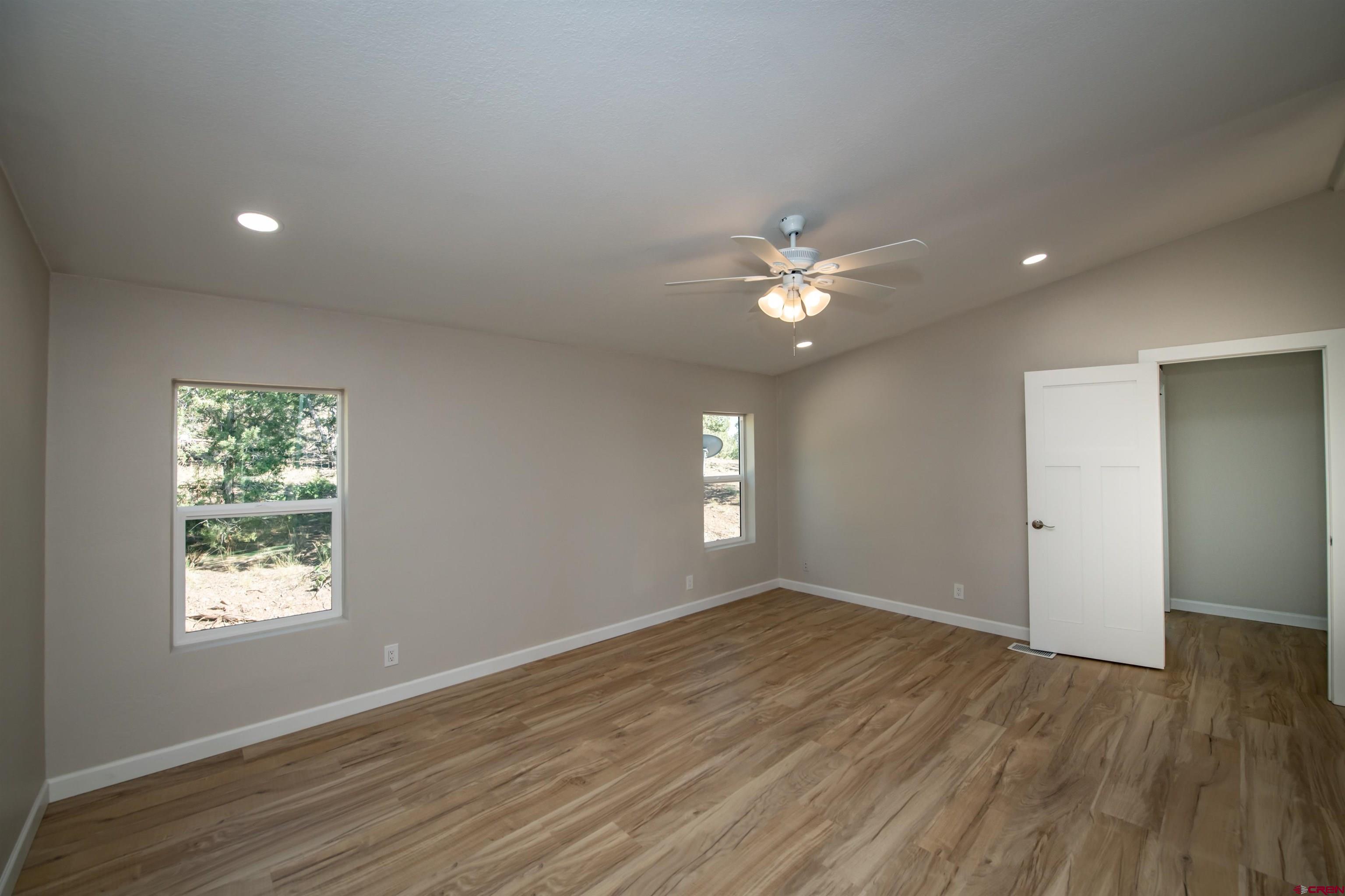 475 Run Around Road Arboles, CO 81121 - Photo 24 of 40 an empty room with wooden floor and windows