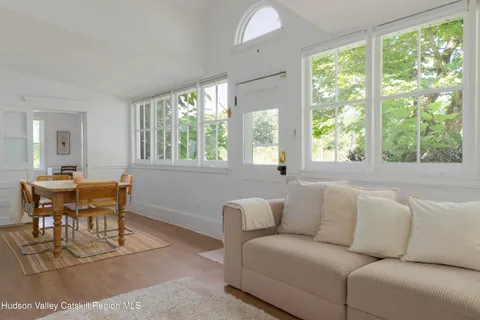 a kitchen with stainless steel appliances granite countertop a stove top oven a sink dishwasher and white cabinets with wooden floor