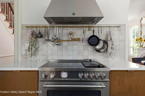 a kitchen with stainless steel appliances a sink a stove a refrigerator and wooden floor