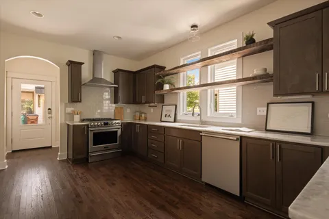 a kitchen with stainless steel appliances granite countertop a stove a sink and a microwave