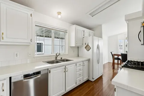 a kitchen with stainless steel appliances granite countertop a stove a sink and a refrigerator
