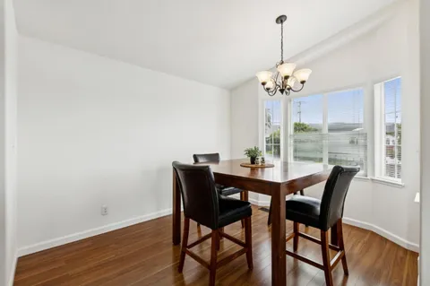 a dining room with furniture a chandelier and window