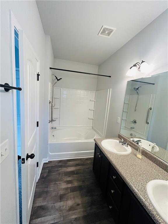 853 Ash Street Canton, GA 30114 - Photo 17 of 23 a bathroom with a granite countertop sink a mirror a bathtub and shower