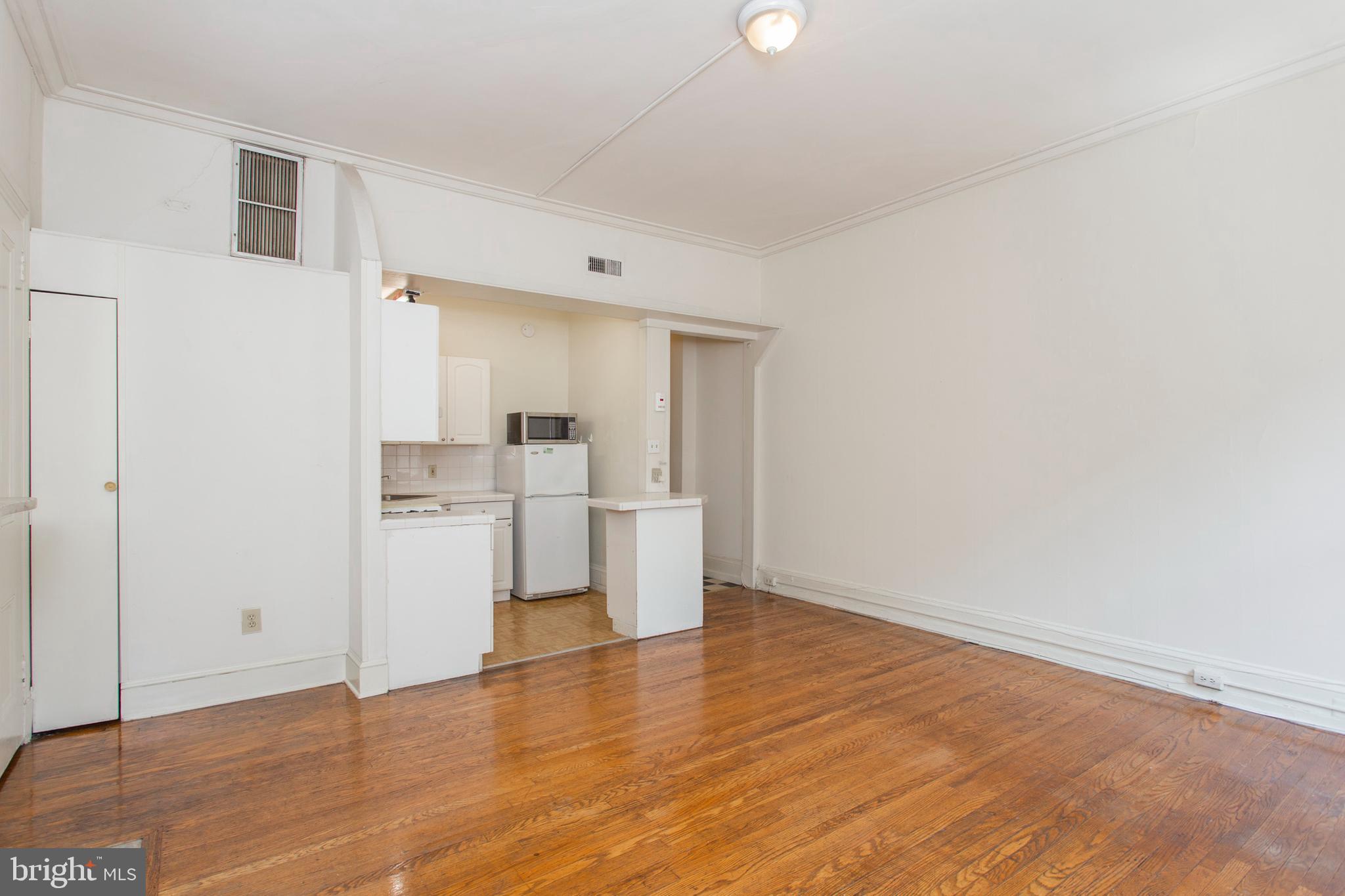 1807 Spruce Street, Unit 2F Philadelphia, PA 19103 - Photo 3 of 17 a view of kitchen and empty room with wooden floor