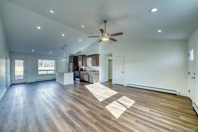 an empty room with windows and ceiling fan