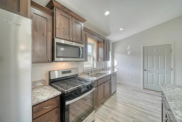 a kitchen with stainless steel appliances granite countertop a stove and a microwave
