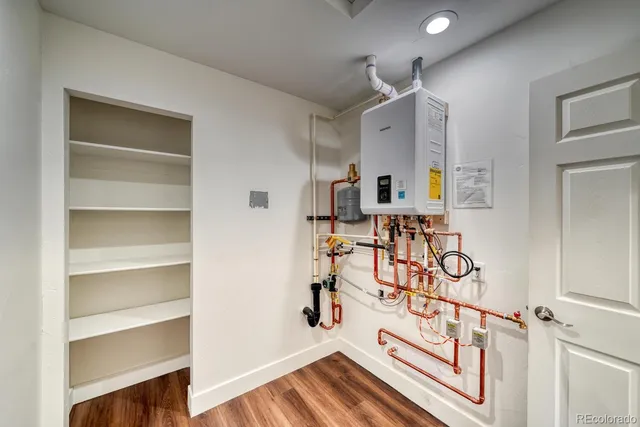 a view of front door with hallway and wooden floor