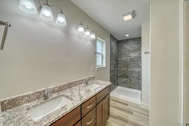 a bathroom with a granite countertop sink and a mirror