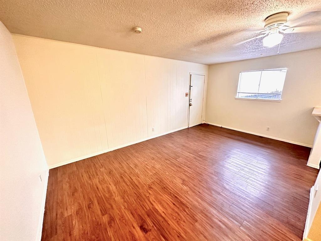 4204 Speedway, Unit 105 Austin, TX 78751 - Photo 2 of 13 an empty room with wooden floor fan and windows