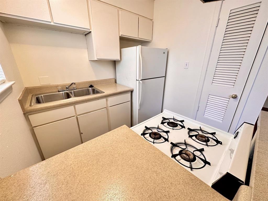 4204 Speedway, Unit 105 Austin, TX 78751 - Photo 5 of 13 a kitchen with a sink appliances and cabinets