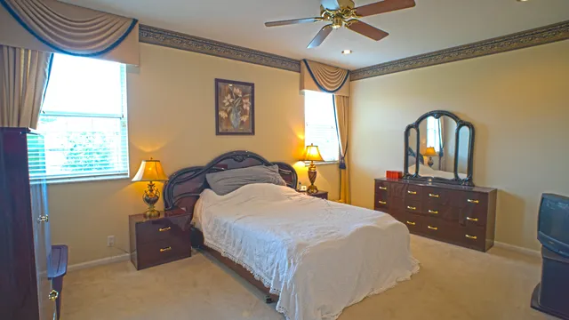 a bedroom with a bed and a dresser with the mirror