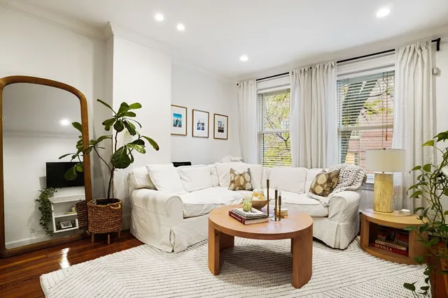 a living room with furniture a window and a flat screen tv