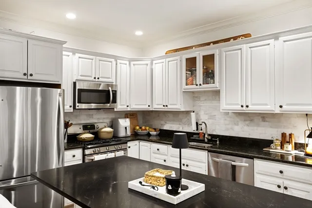 a kitchen with granite countertop a sink a stove and refrigerator