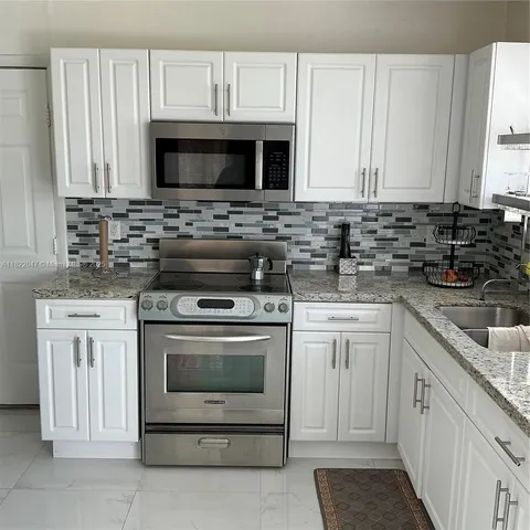 a dining room with furniture and a potted plant