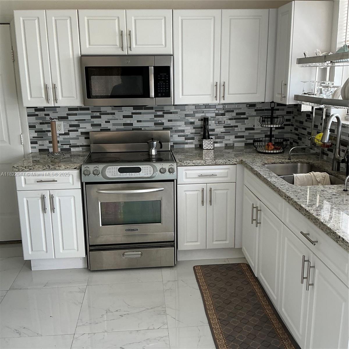 1924 Northwest 35th Street Miami, FL 33142 - Photo 20 of 29 a kitchen with granite countertop a stove sink microwave and cabinets