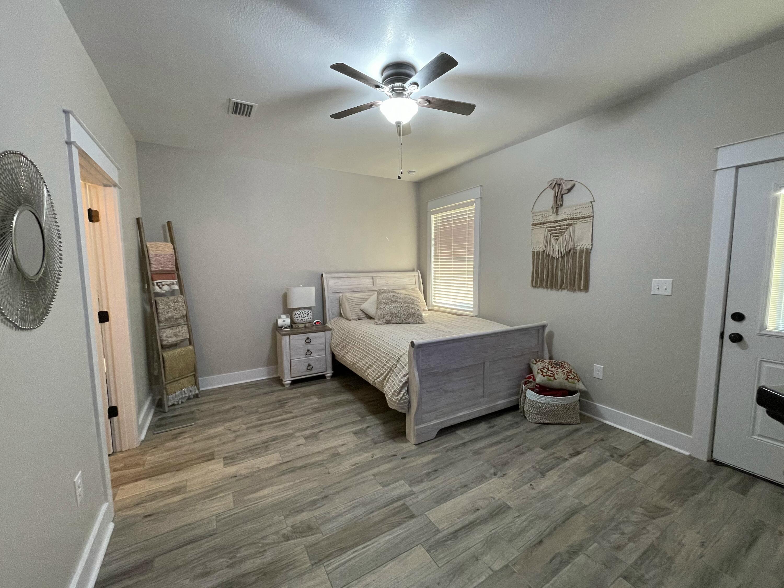 4087 Happy Trails Road Crestview, FL 32539 - Photo 15 of 30 a spacious bedroom with a bed and a ceiling fan