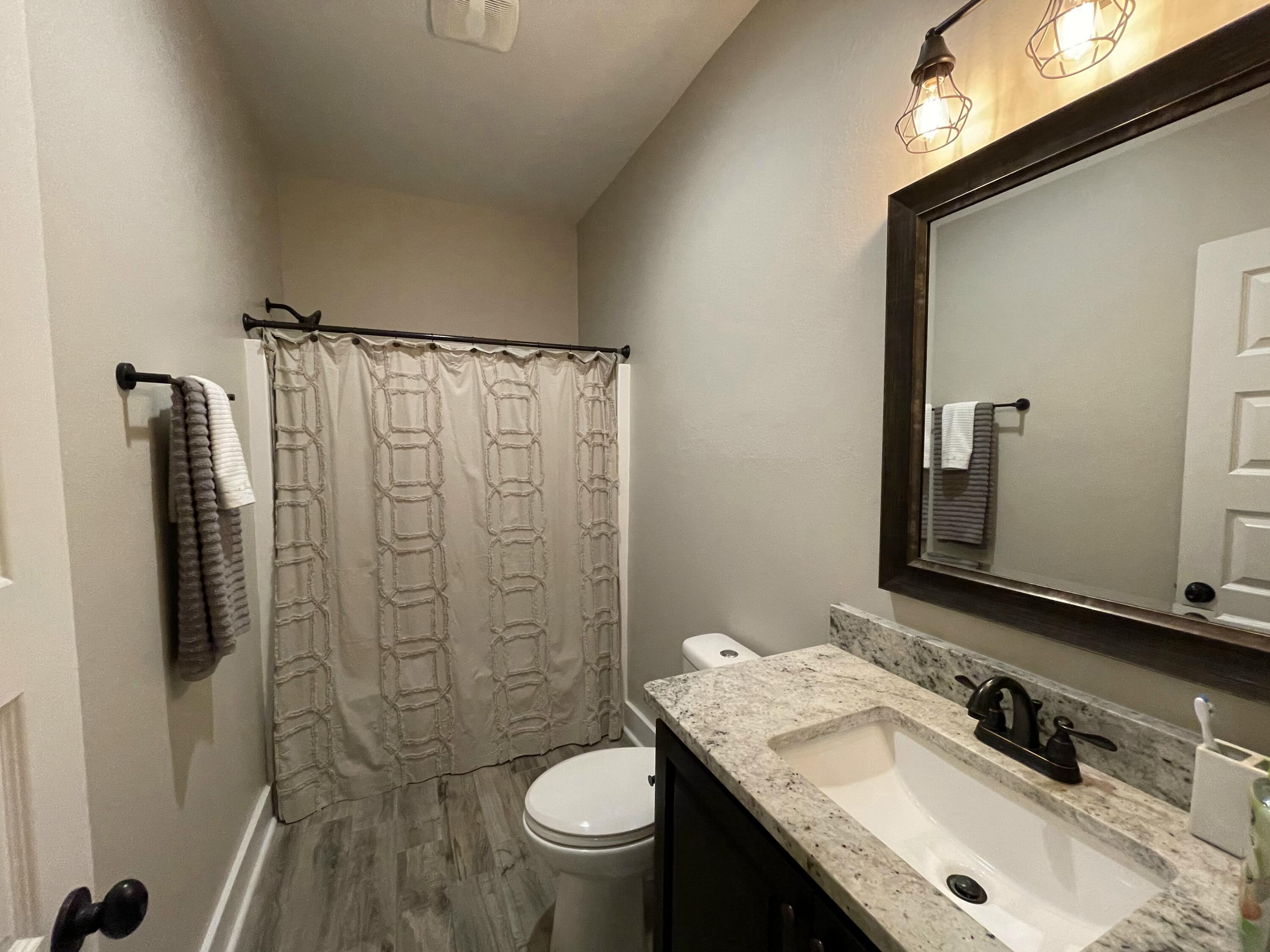 4087 Happy Trails Road Crestview, FL 32539 - Photo 22 of 30 a bathroom with a granite countertop sink toilet and shower