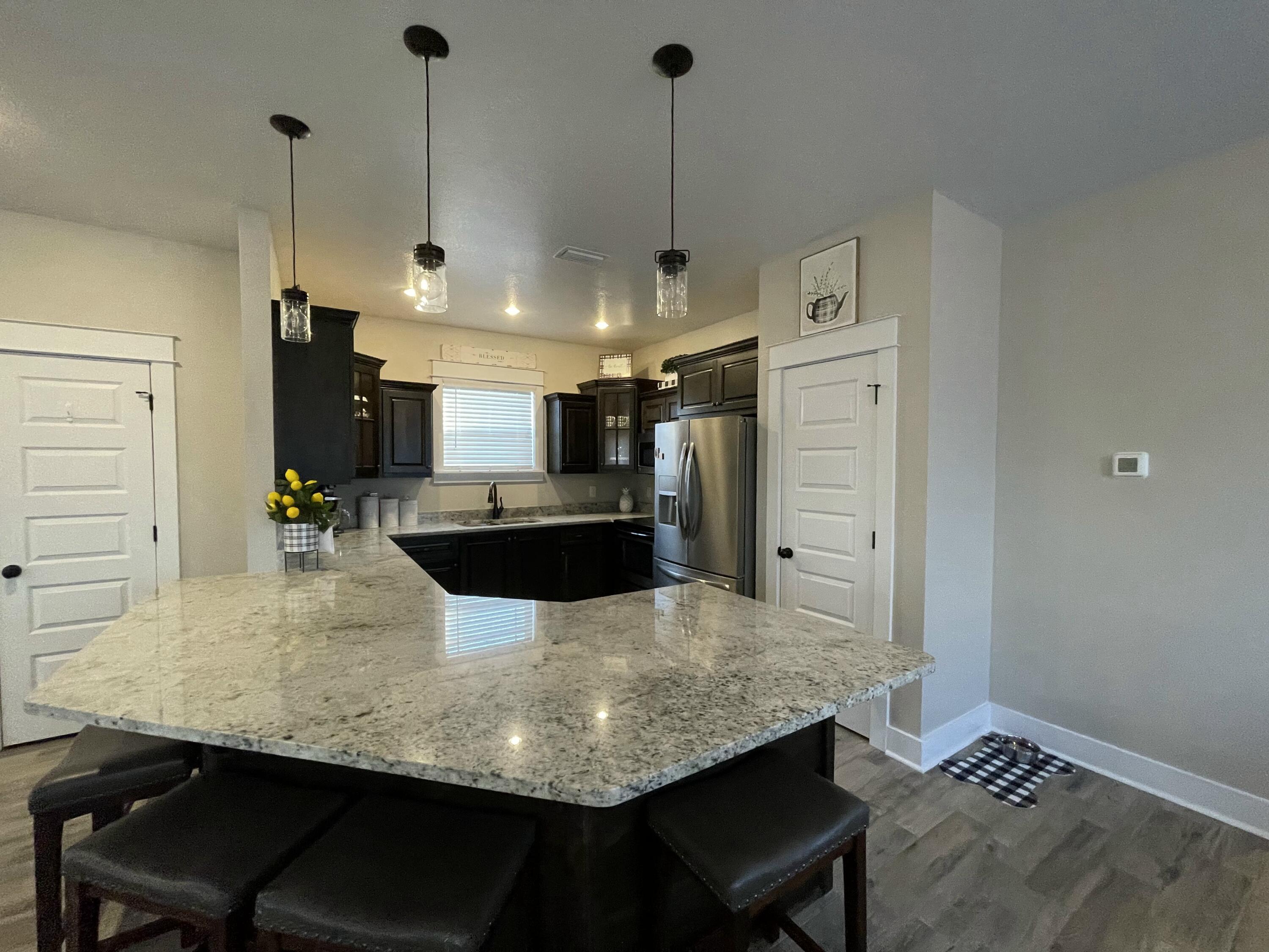 4087 Happy Trails Road Crestview, FL 32539 - Photo 9 of 30 a kitchen with stainless steel appliances kitchen island granite countertop a table chairs and a refrigerator